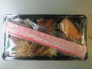 うなぎ、金目鯛と銀鮭のあいのせ御膳 包み紙を外したところ