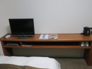 ホテルドーミーイン稚内 ダブルルーム テーブル テレビと電気ケトル、マグカップがあります