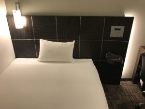 ホテル アクティブ! 博多 シングルルーム ベッド 枕元に目覚まし時計とスマホ置き場があります
