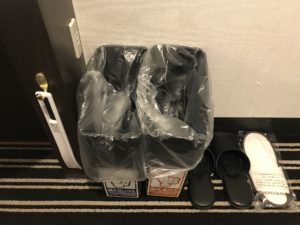 アパホテル 新宿 歌舞伎町タワー シングルルーム デスク横 ACコンセントとごみ入れ スリッパがあります