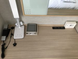 名鉄イン浜松町 シングルルーム デスク上 目覚まし時計とコンセント、有線LAN、照明、電話、ケータイ・スマホ充電ケーブルがあります