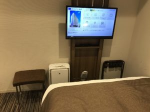 京王プレッソイン浜松町 シングルルーム ベッド向かい 液晶テレビ、加湿空気清浄機、スリッパがあります