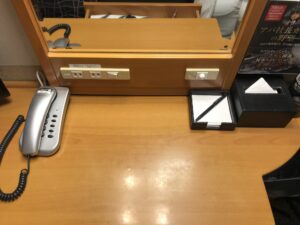 アパホテル 高崎駅前 シングル デスク回り 電話、ACコンセント、デスク照明のスイッチ、メモ、ティッシュがあります