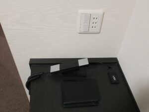 天然温泉間門の湯 ホテルドーミーインPREMIUM下関 ダブルルーム デスク上 ACコンセントと電話機、有線LANコネクタがあります