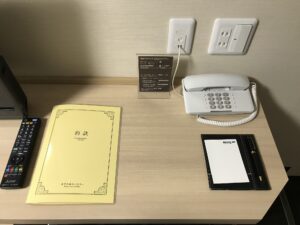 ドーミーイン・global cabin浅草 クイーンルーム デスク上 電話機、有線LAN、ACコンセント、デスク灯のスイッチがついています
