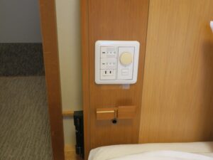 ドーミーイン津 和風シングル ベッド脇のスイッチ類 照明のスイッチとACコンセントがあります