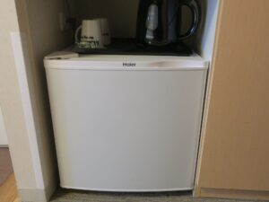 ドーミーイン津 和風シングル 洗面台下 冷蔵庫とマグカップ、電気ケトルがあります