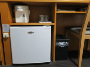 秋田天然温泉 ルートイングランティア秋田 SPA RESORT ダブルルーム デスク下 電気ポットと冷蔵庫、マグカップ、コップ、ごみ箱、ドライヤーがあります