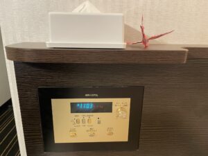 アパホテル 京成成田駅前 シングルルーム 枕元 ティッシュと目覚まし時計、照明のスイッチがあります