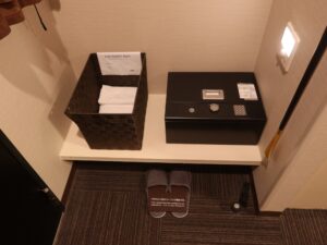 ドーミーイン熊本 セミダブルルーム 玄関わきのセーフティーボックスとタオル、スリッパ