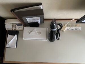 ホテルハーバー横須賀 シングルルーム デスク上 電話機、メモ帳、ティッシュ、ドライヤー ACコンセント 明かりのスイッチ 有線LANコネクタがあります