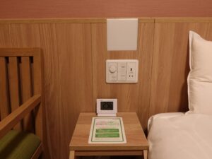 ドーミーイン水戸 ダブルルーム ベッド脇のスイッチとテーブル、目覚まし時計